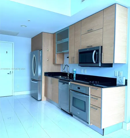 a kitchen with stainless steel appliances granite countertop a refrigerator and a stove top oven