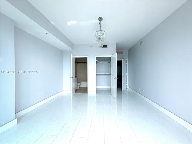 a view of an empty room with a kitchen