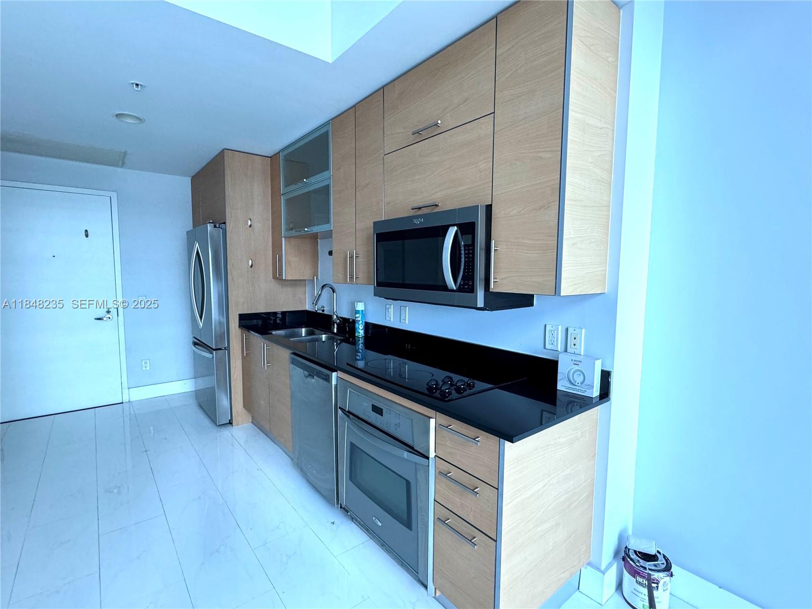 60 Southwest 13th Street, Unit 3408 Miami, FL 33130 - Photo 4 of 27 a kitchen with stainless steel appliances a sink and wooden cabinets