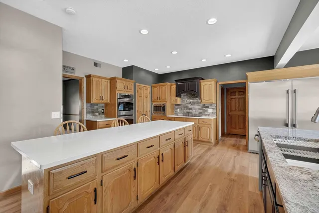 a large kitchen with kitchen island a large island in it