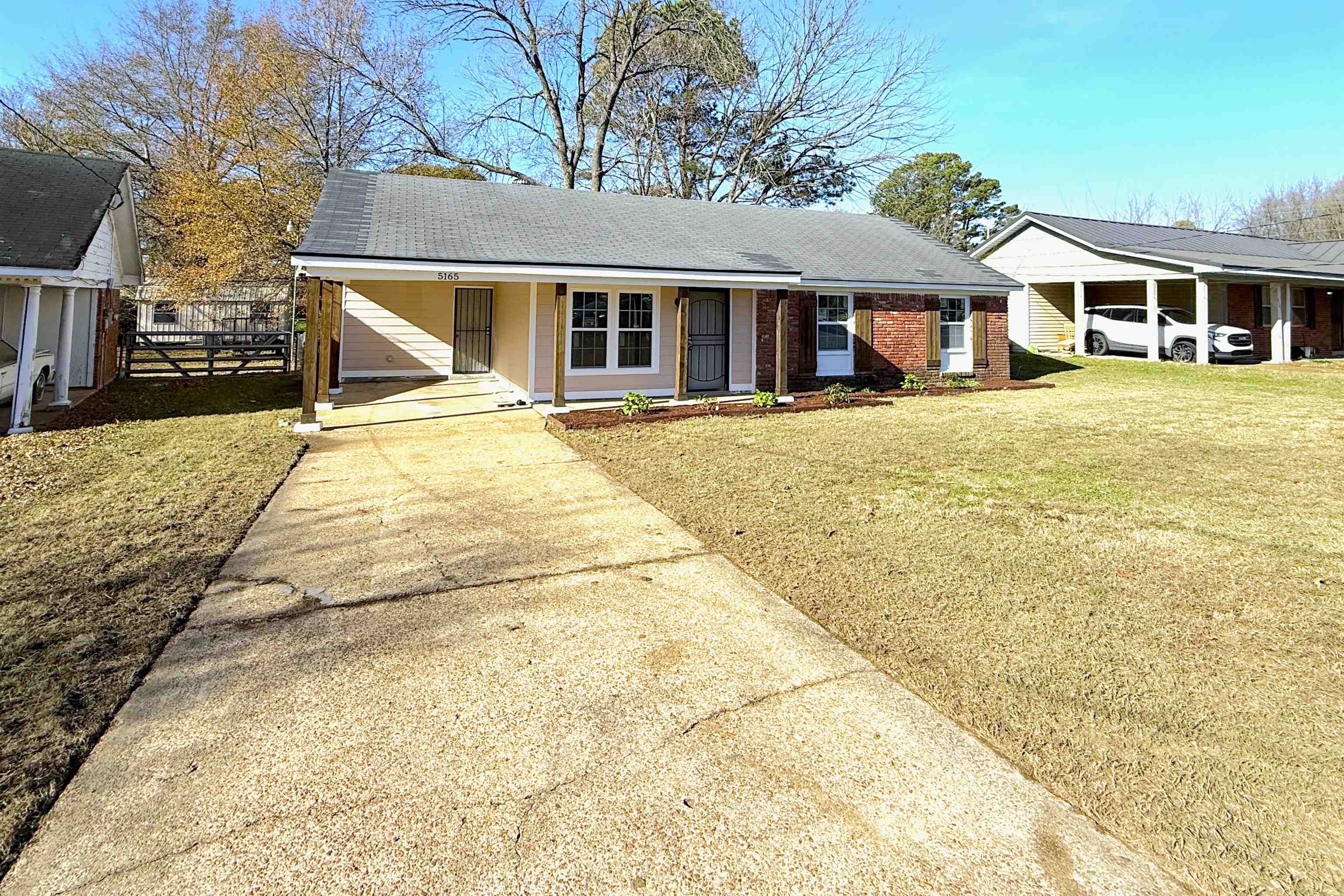 5165 Sea Shore Road Memphis, TN 38109 - Photo 16 of 20 Ranch-style home with concrete driveway, an attached carport, covered porch, and roof with shingles