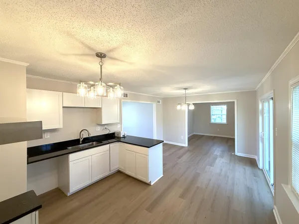 a kitchen with granite countertop a sink and cabinets