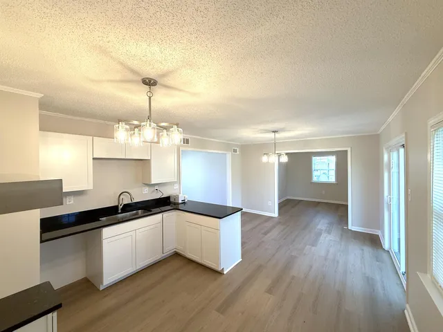 a kitchen with granite countertop a sink and cabinets