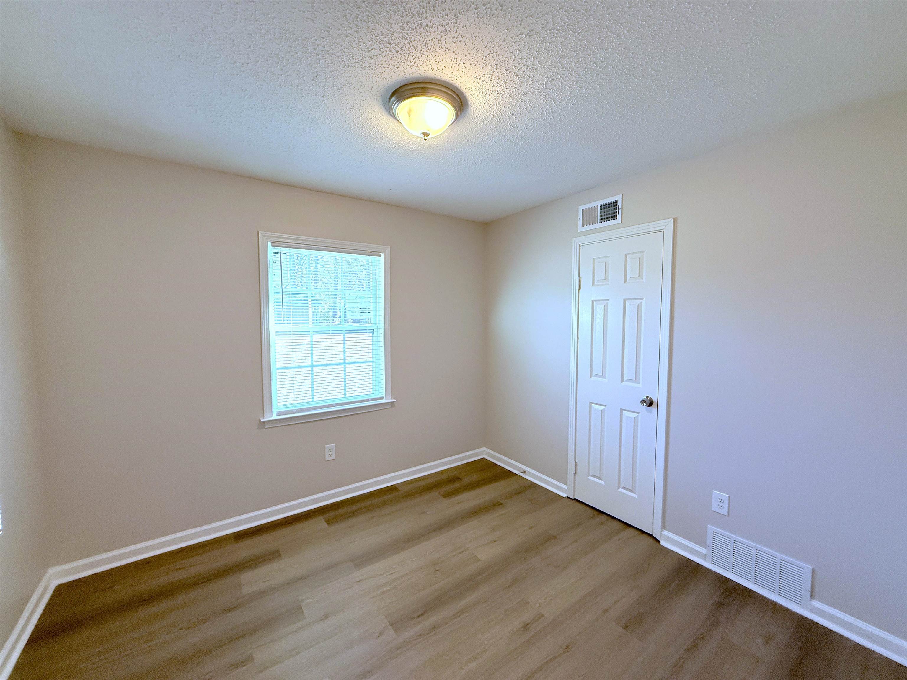 5165 Sea Shore Road Memphis, TN 38109 - Photo 10 of 20 Empty room with a textured ceiling and wood finished floors
