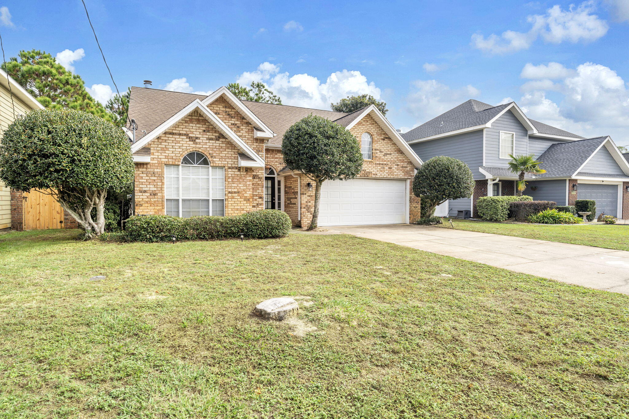 a view of a house with a yard and potted plants