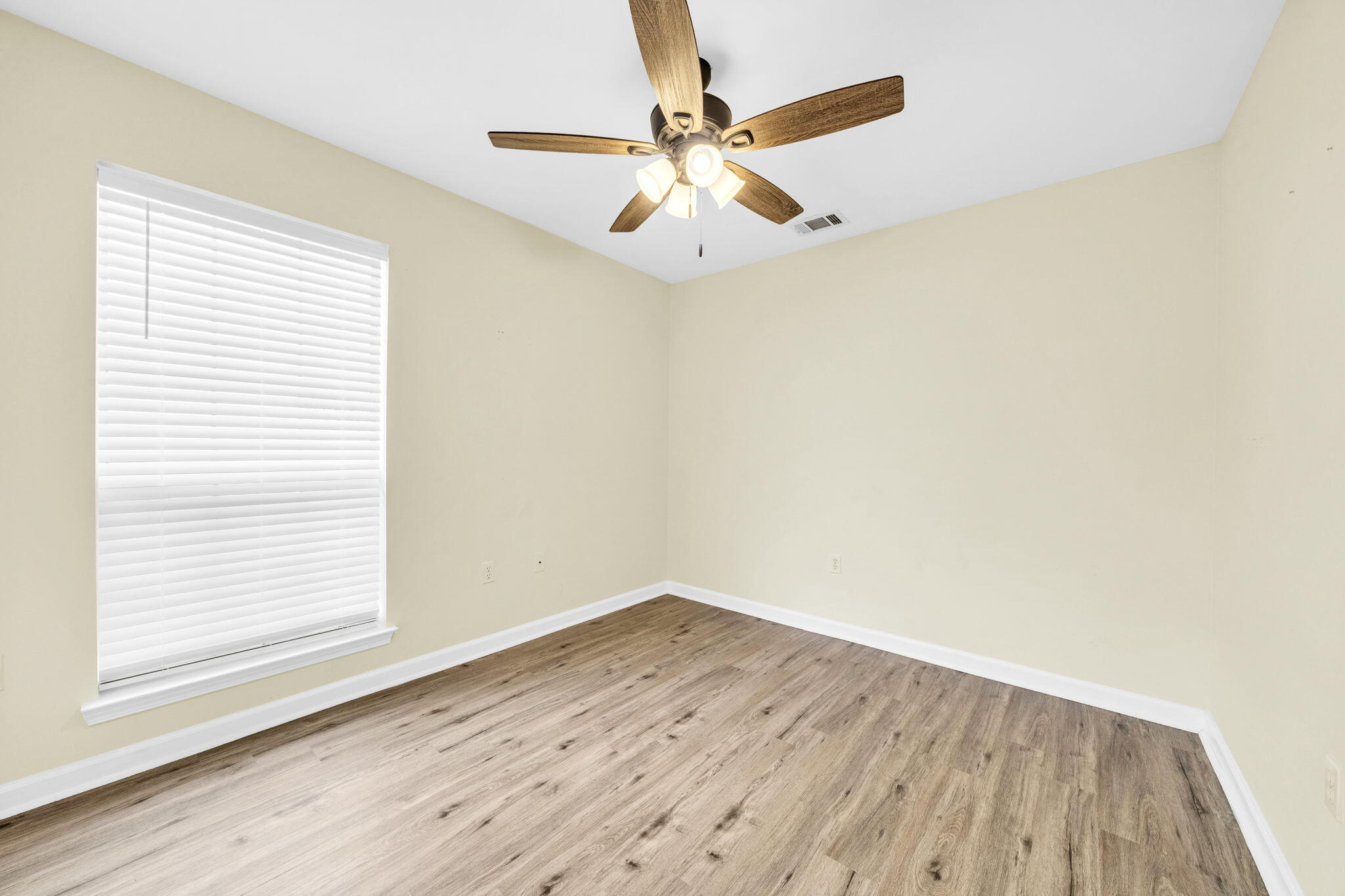 59 Hidden Lakes Drive Destin, FL 32550 - Photo 8 of 39 an empty room with wooden floor fan and windows