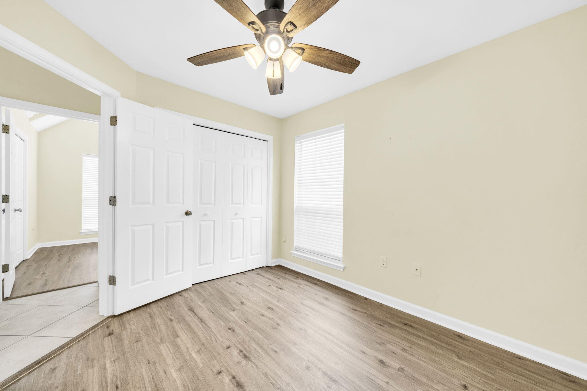 59 Hidden Lakes Drive Destin, FL 32550 - Photo 9 of 39 an empty room with wooden floor chandelier fan and windows
