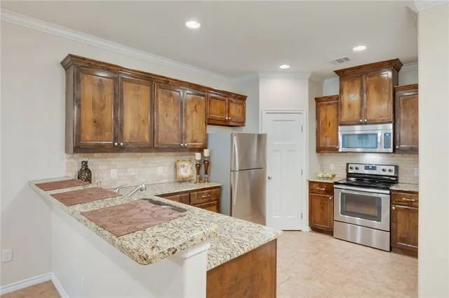 a kitchen with stainless steel appliances granite countertop a sink stove and refrigerator