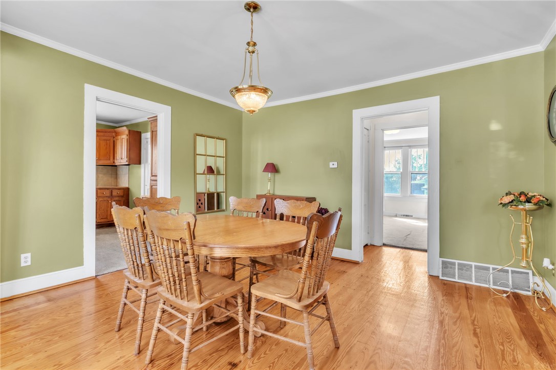 121 Ellison Street Belton, SC 29627 - Photo 10 of 30 Bright and inviting dining area with natural wood floors and an elegant light fixture.