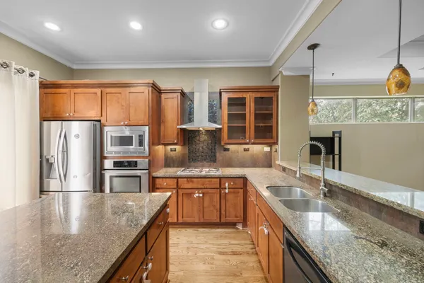 a kitchen with stainless steel appliances granite countertop a sink and a refrigerator