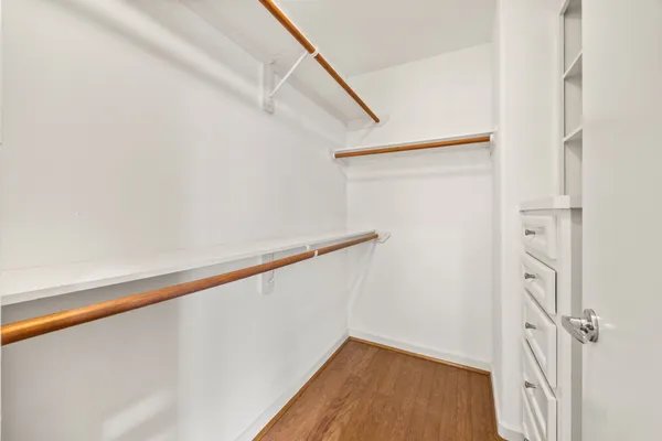 a view of walk in closet with empty racks