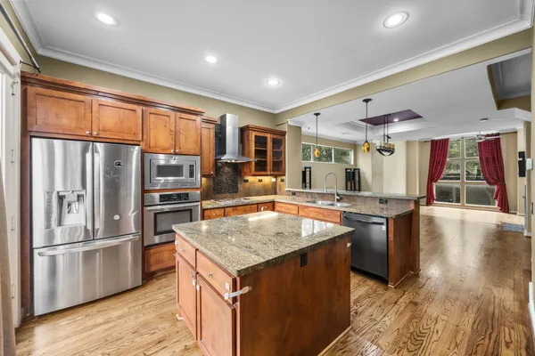 a kitchen with stainless steel appliances granite countertop a sink a stove and a refrigerator