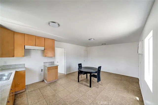 a view of kitchen with furniture and electronic appliances