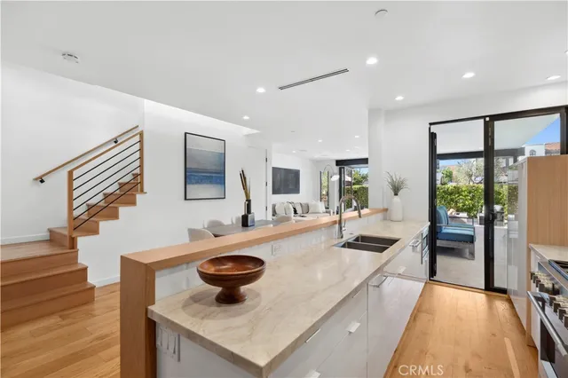 a large kitchen with stainless steel appliances kitchen island granite countertop a refrigerator and a sink