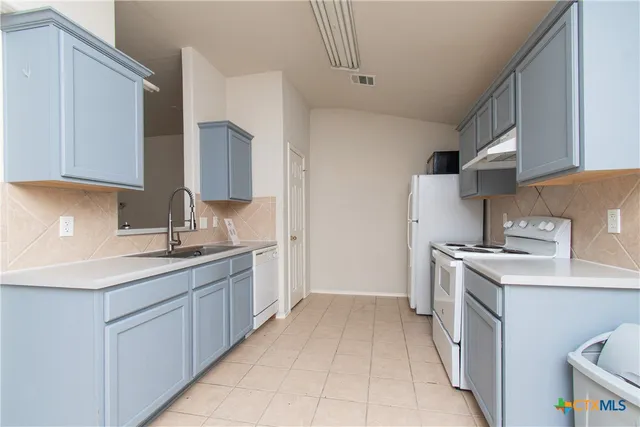 a kitchen with a sink stove and cabinets
