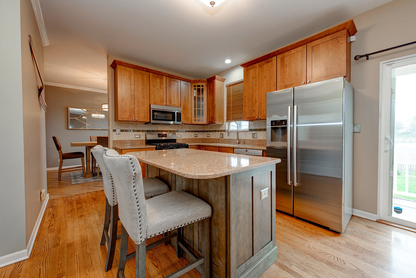866 Deer Path Drive Antioch, IL 60002 - Photo 8 of 28 a kitchen with stainless steel appliances granite countertop a refrigerator a stove a sink a dining table and chairs with wooden floor