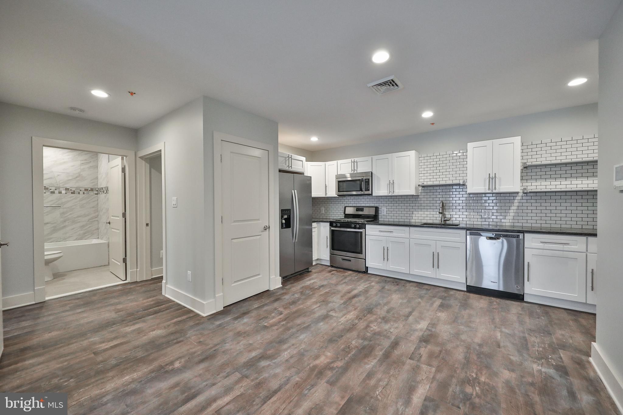 a large kitchen with stainless steel appliances granite countertop a stove a sink and a refrigerator