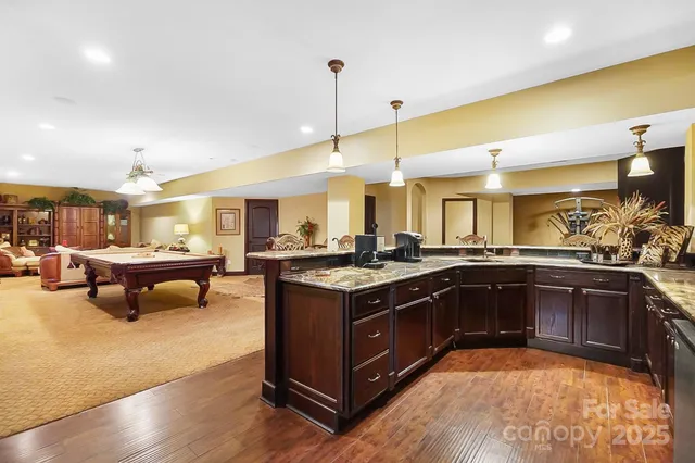 a living room with furniture pool table and windows