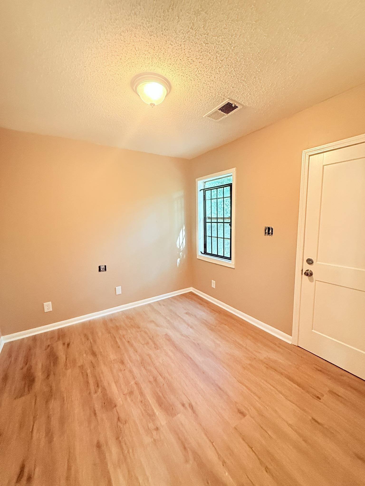 931 Calvin Road Memphis, TN 38109 - Photo 11 of 15 Spare room featuring a textured ceiling and light wood-type flooring