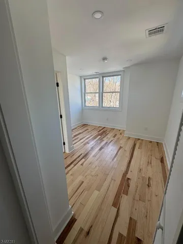 a view of a room with wooden floor and windows