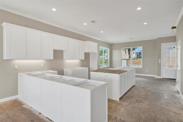 an empty room with windows and fireplace