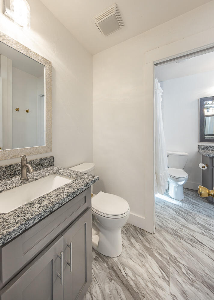 4816 40th Street Lubbock, TX 79414 - Photo 15 of 21 a bathroom with a granite countertop toilet sink and a mirror