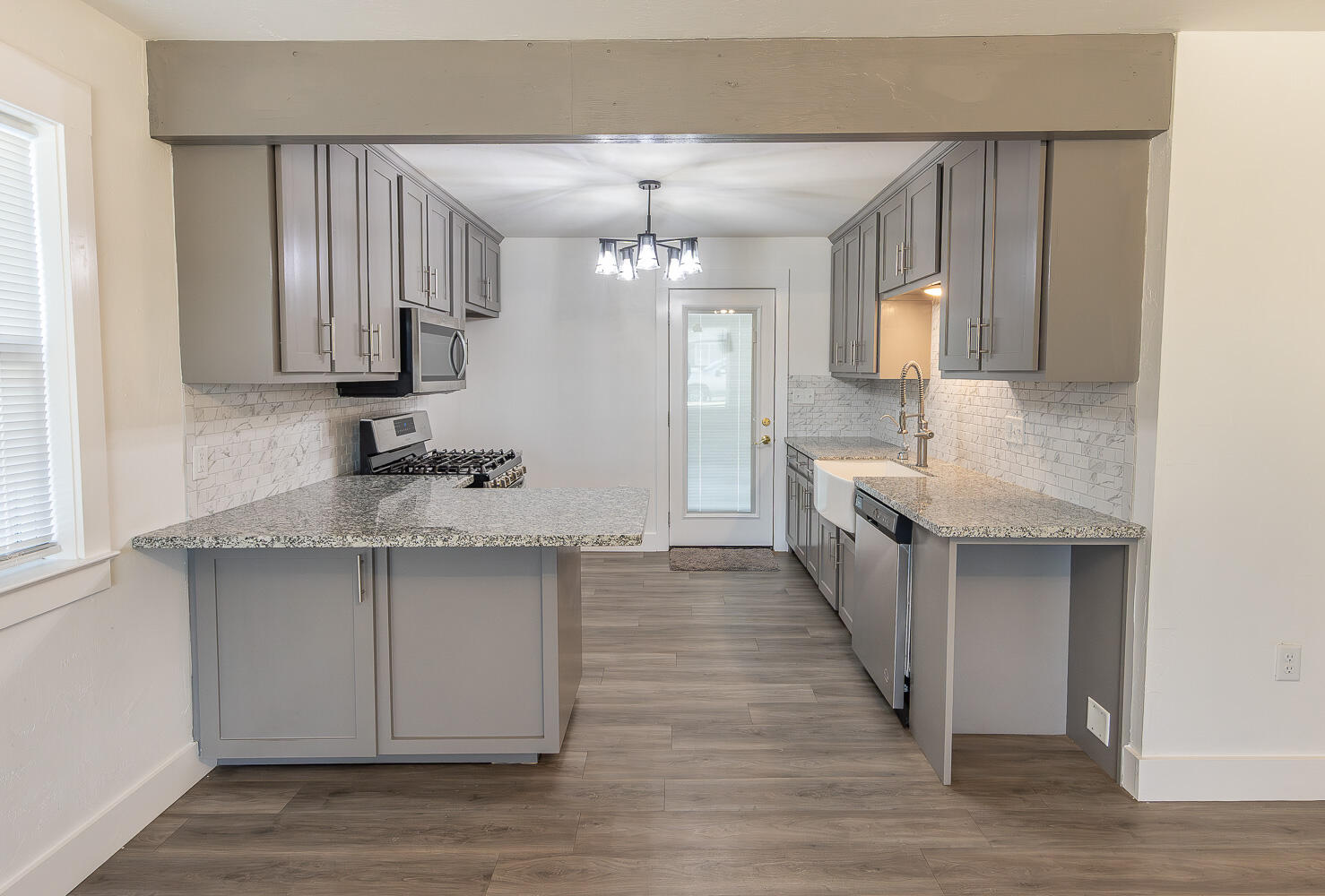 4816 40th Street Lubbock, TX 79414 - Photo 6 of 21 a large kitchen with stainless steel appliances a large counter top a sink a stove and cabinets