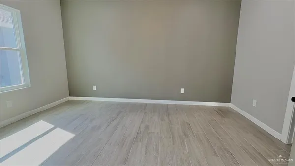 a view of an empty room with wooden floor