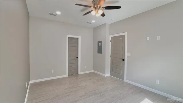 an empty room with closet and a chandelier fan