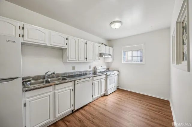 a kitchen with granite countertop a sink and cabinets