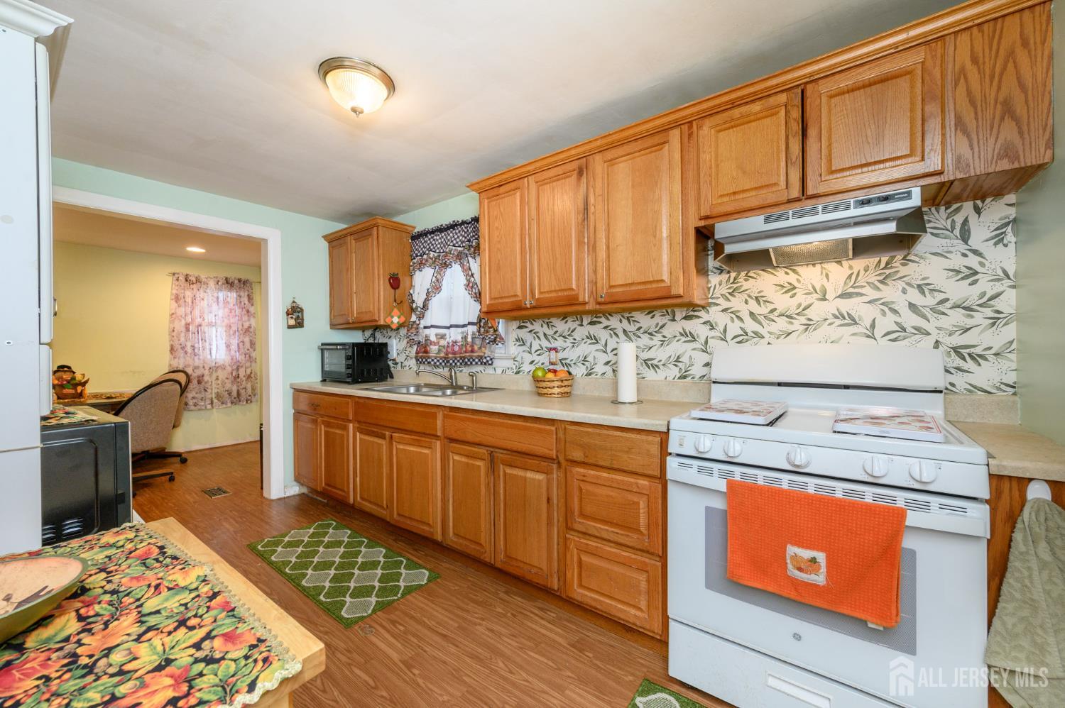 4 Homestead Avenue Avenel, NJ 07001 - Photo 6 of 40 a kitchen with stainless steel appliances granite countertop wooden cabinets stove top oven and sink