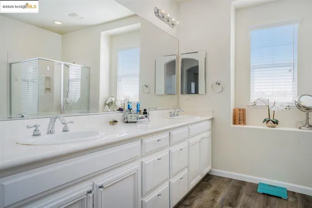 a bathroom with double vanity sinks and a mirror