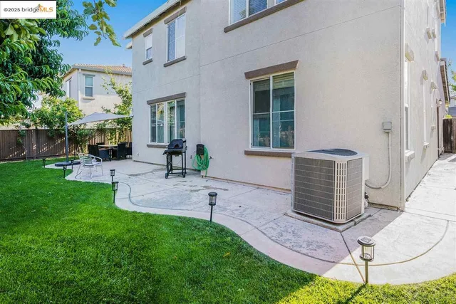 a backyard of a house with yard table and chairs