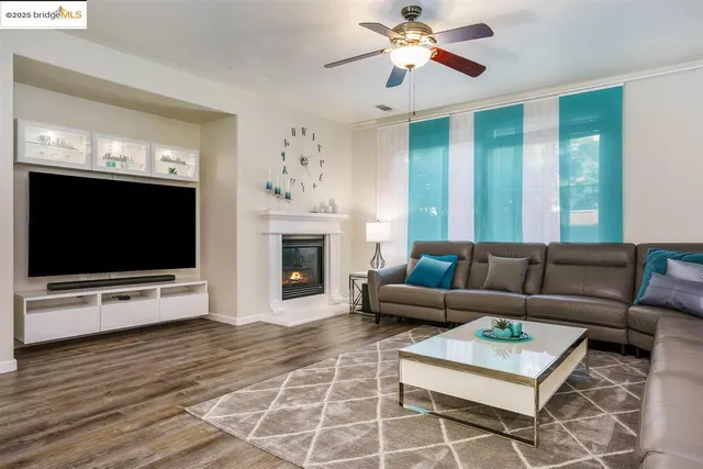 a living room with furniture a flat screen tv and a fireplace