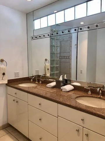 a bathroom with a granite countertop sink and a mirror