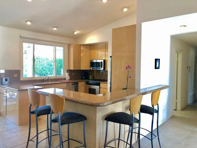 a kitchen with stainless steel appliances granite countertop a stove a sink and a refrigerator