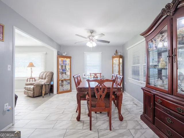 a large dining space with furniture a chandelier and wooden floor