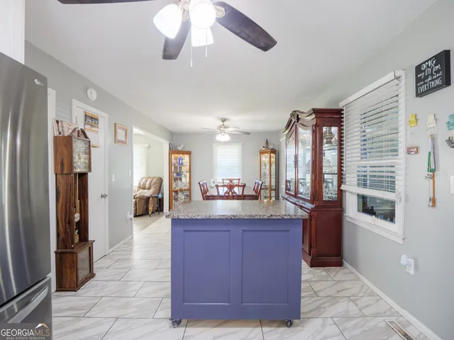 a kitchen with granite countertop stainless steel appliances a sink and a refrigerator