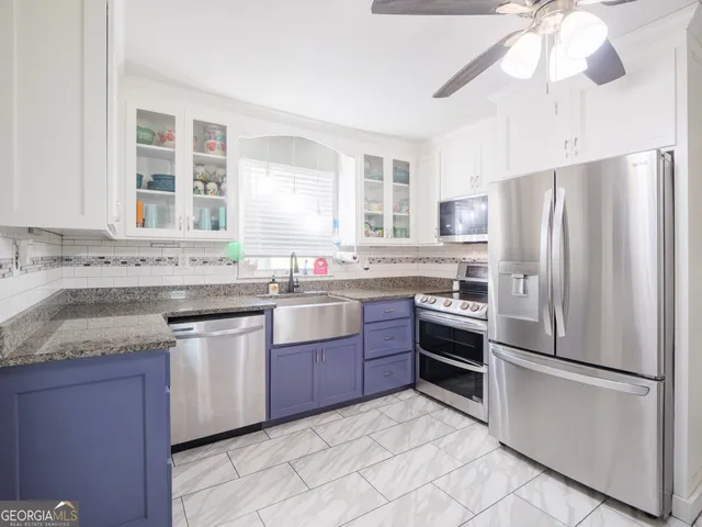 a kitchen with stainless steel appliances kitchen island granite countertop a stove a sink and a cabinets
