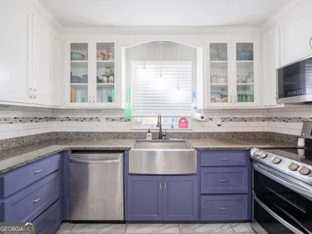 a kitchen with stainless steel appliances granite countertop a refrigerator and a sink