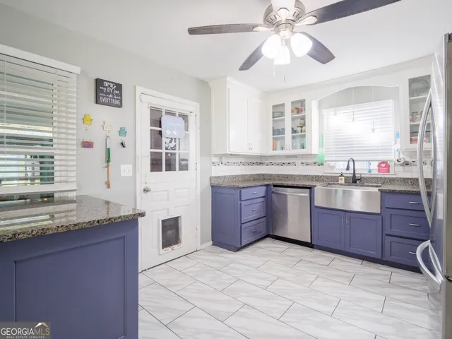 a kitchen with stainless steel appliances granite countertop a sink refrigerator and cabinets