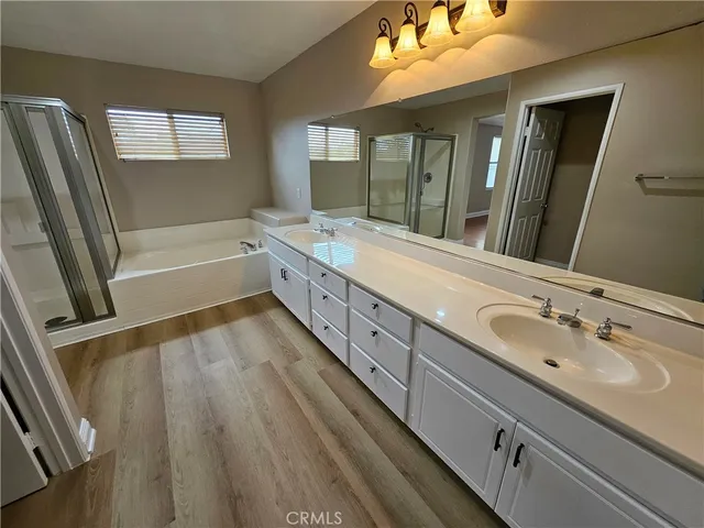a bathroom with a double vanity sink a mirror and a bathtub