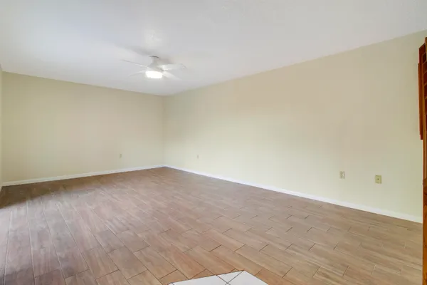 a view of an empty room with wooden floor