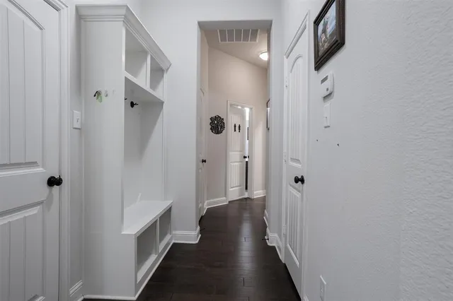 a view of a hallway with wooden floor and closet area