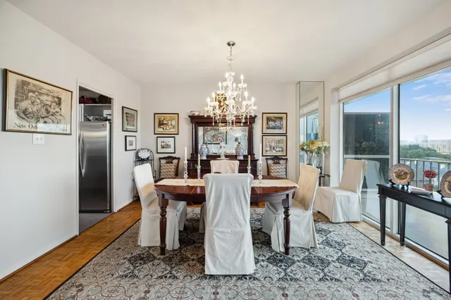 a dining room with furniture a chandelier and wooden floor