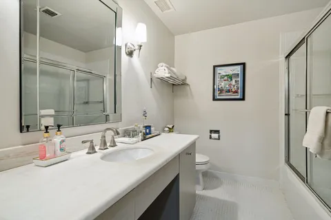 a bathroom with a sink a toilet and shower