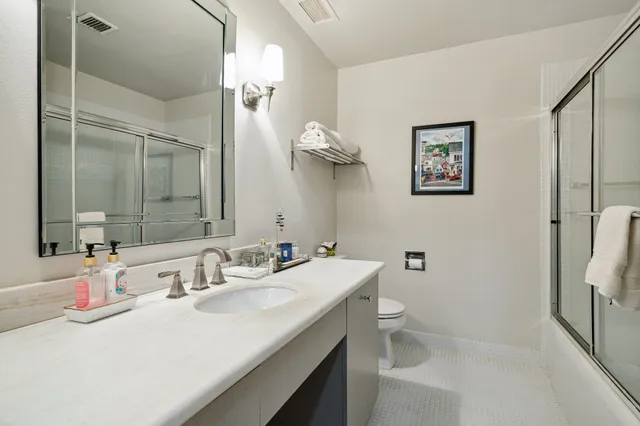 a bathroom with a sink a toilet and shower