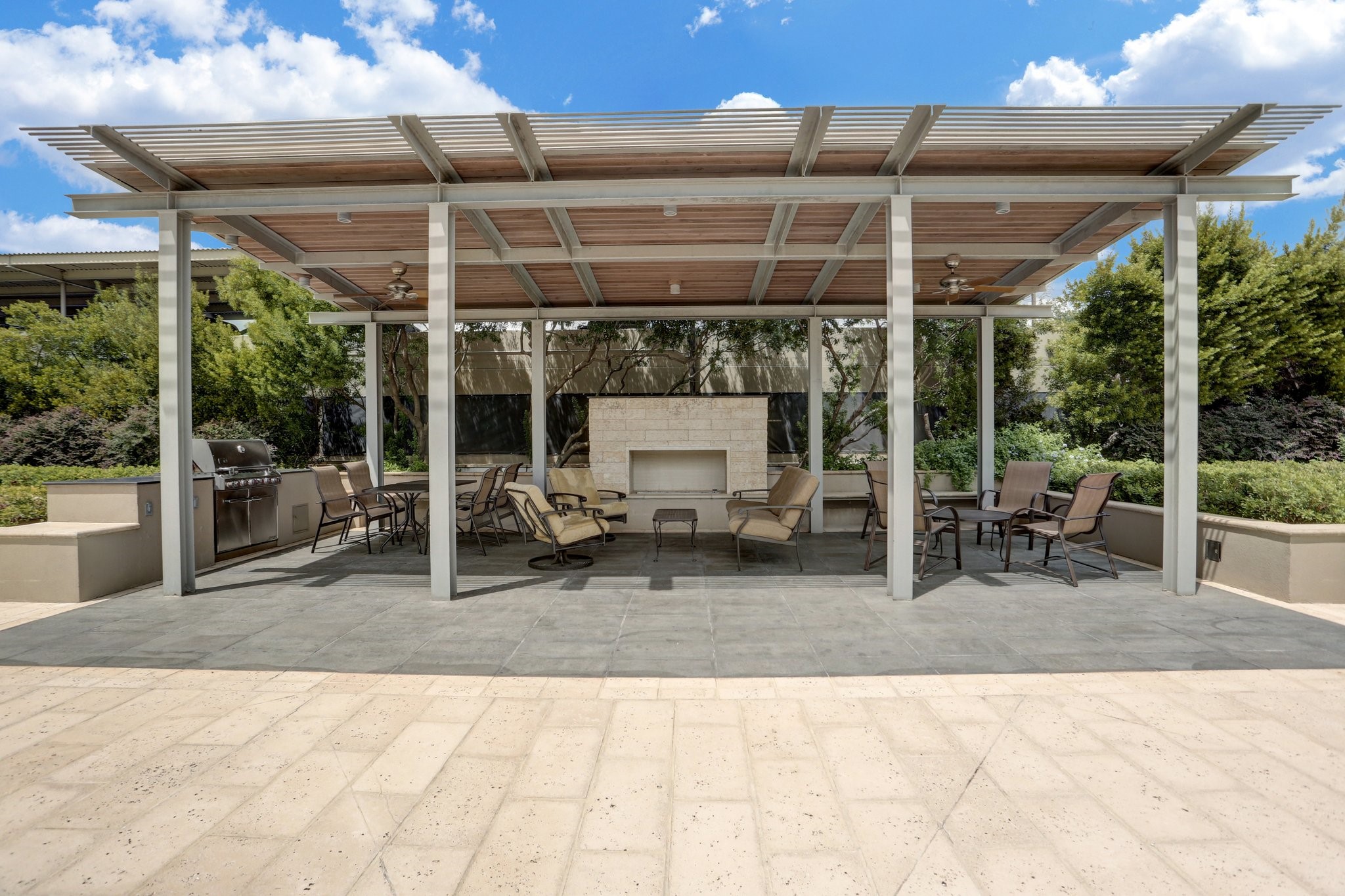 2200 Willowick Road, Unit 7B Houston, TX 77027 - Photo 27 of 32 a view of a patio with table and chairs under an umbrella with a small yard