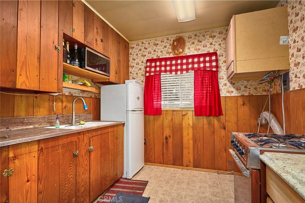 1244 Lark Road Wrightwood, CA 92397 - Photo 14 of 26 a kitchen with stainless steel appliances granite countertop a stove a sink and a microwave