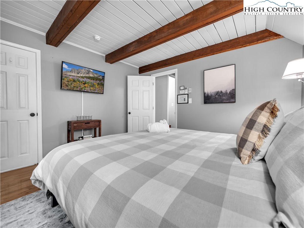 404 Charter Hills Road Beech Mountain, NC 28604 - Photo 13 of 36 a bedroom with a large bed and a chandelier